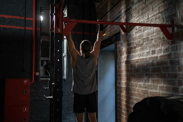 A man carefully setting up equipment for a workout session.